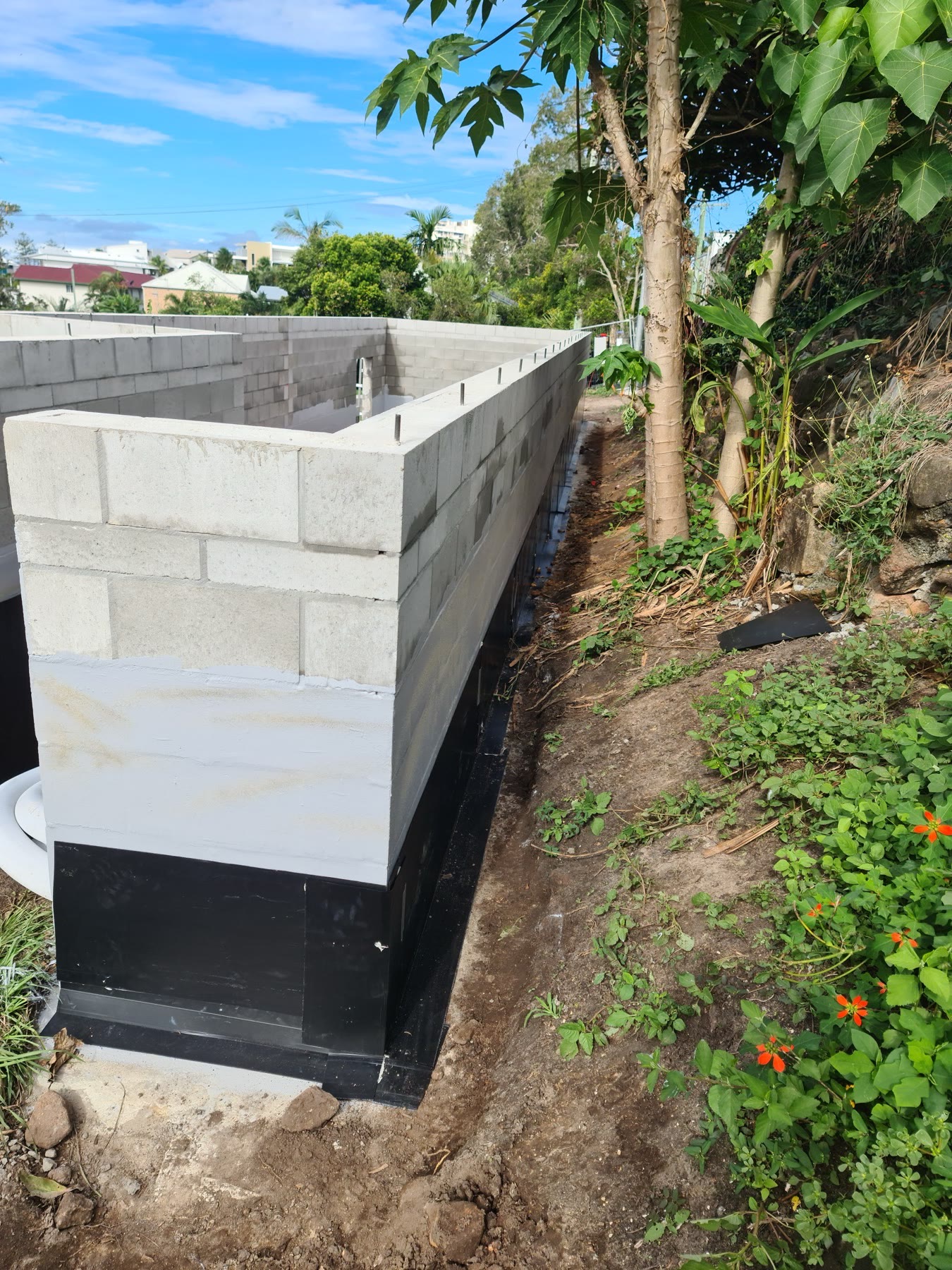 Retaining wall waterproofing on a Sunshine Coast hillside site